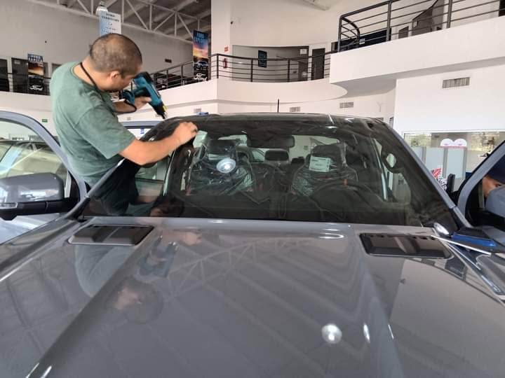 Técnico instalando película en parabrisas